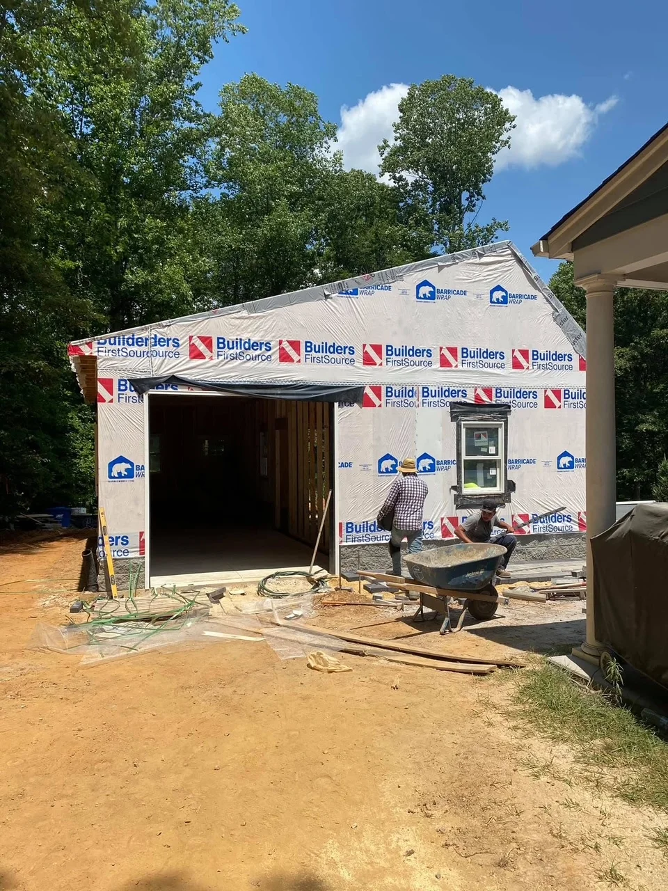 New home addition with framed walls, gable roof, house wrap, and weather barrier installed