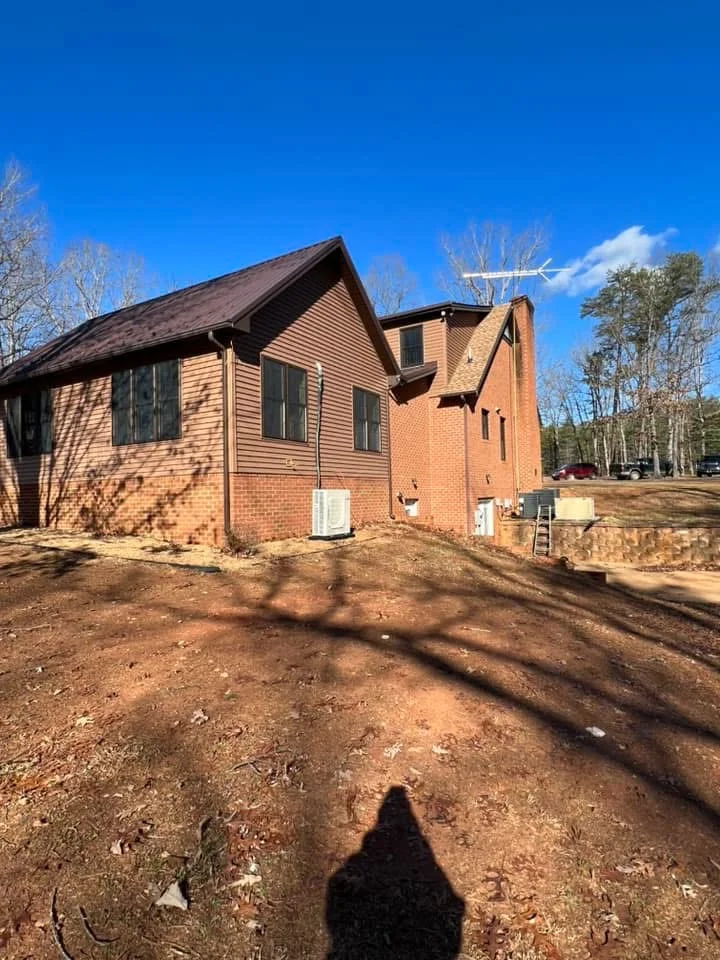 Brick and vinyl siding residential addition with peaked roof and multi-window design