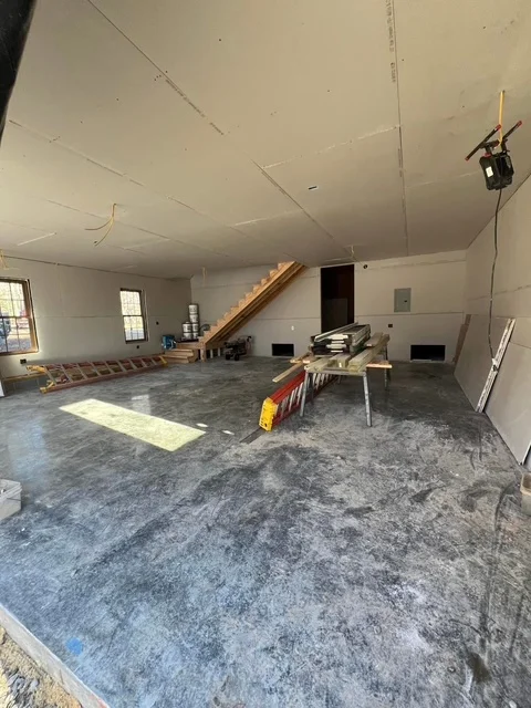 Drywall ceiling installation, framed walls, electrical rough-in, concrete floor in large interior space