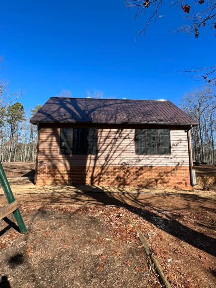 New residential addition with vinyl siding, metal roof, and brick foundation