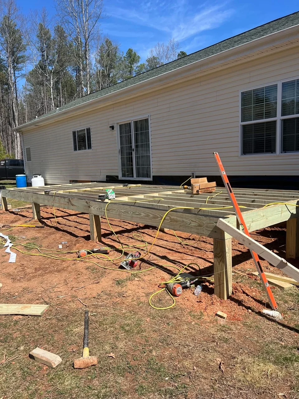 Pressure-treated wood deck framing with joists and posts under construction on mobile home