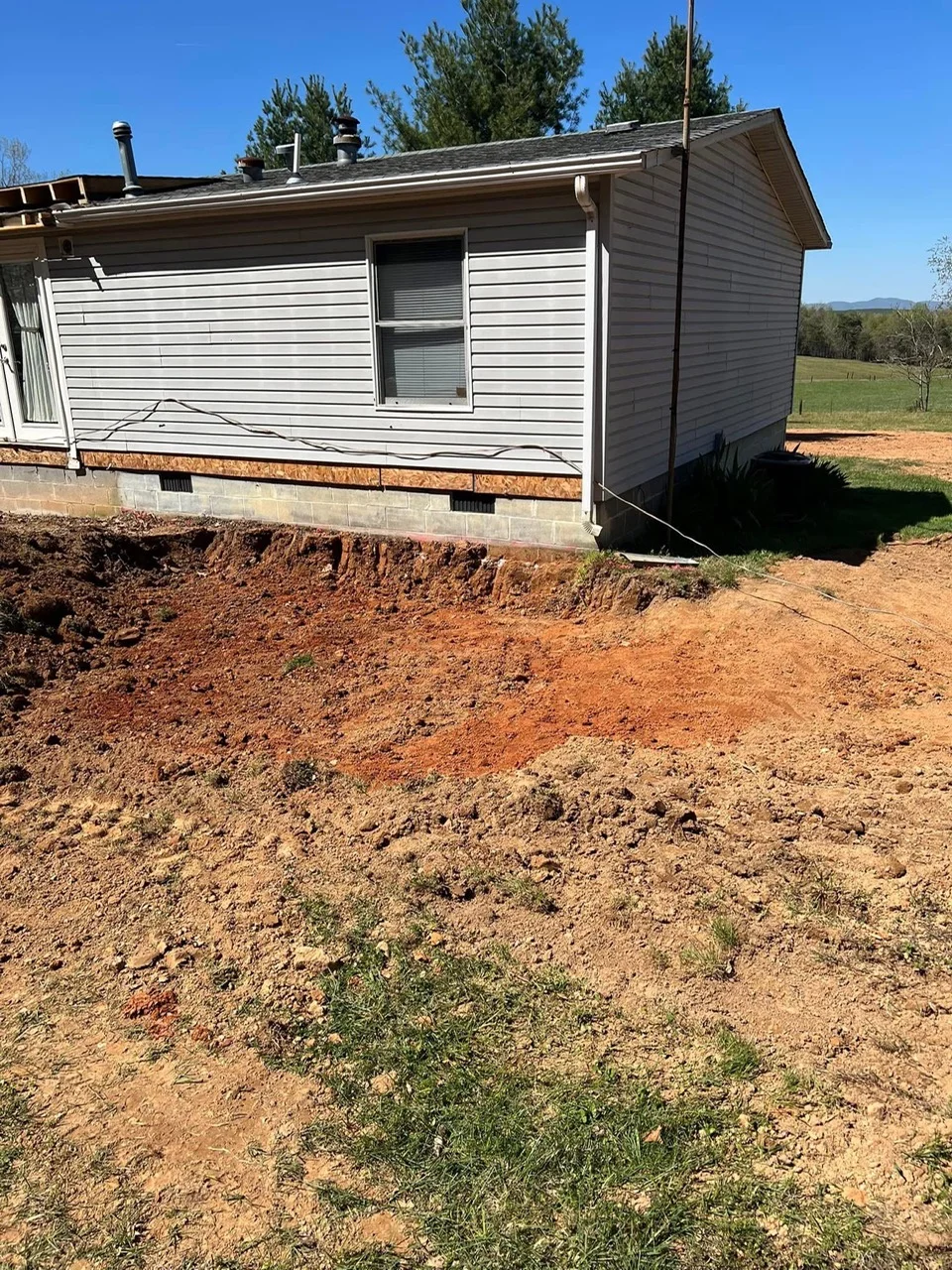 Mobile home on concrete block foundation with graded dirt site and proper drainage setup